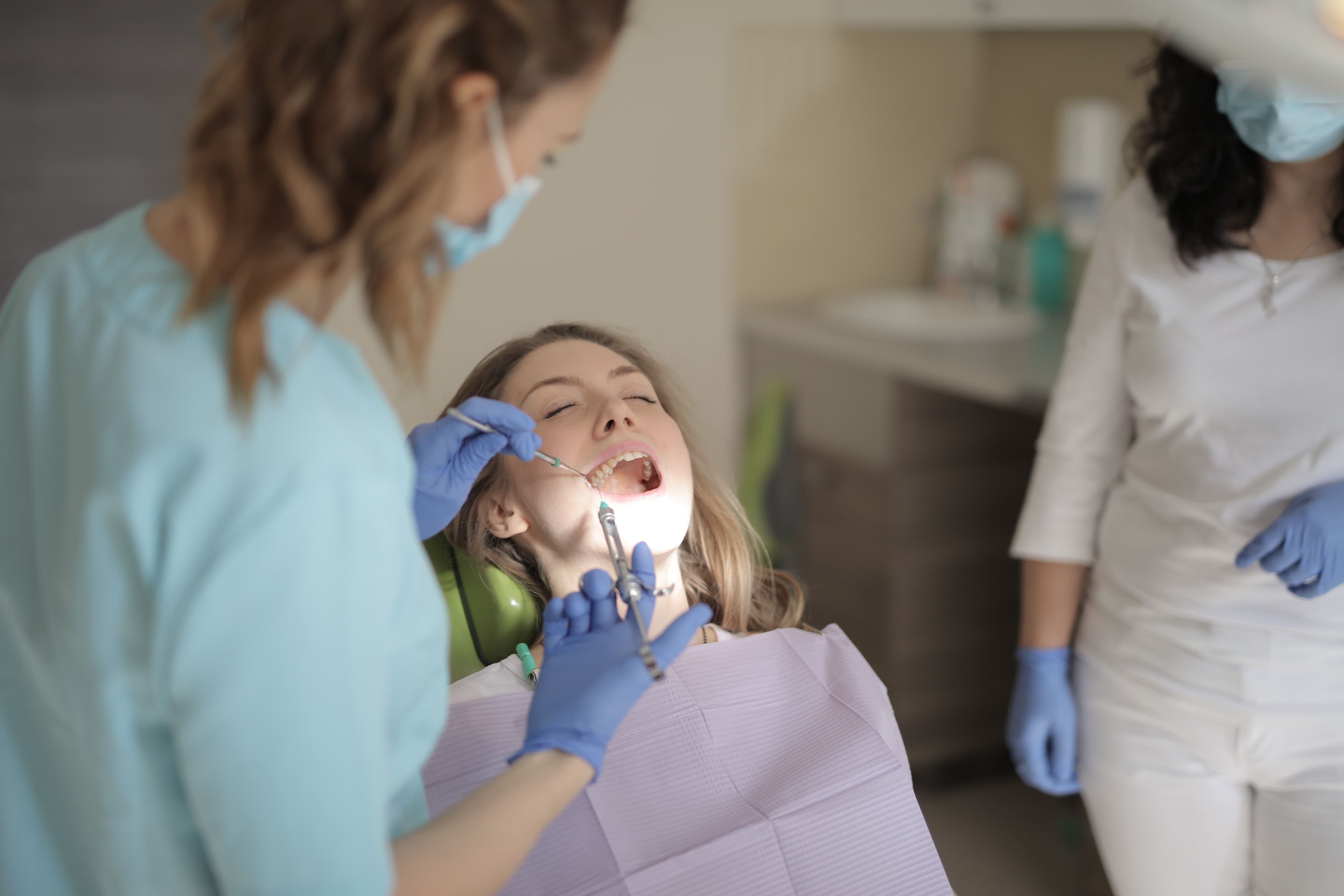 A young girl in a dental chair during a cleaning procedure